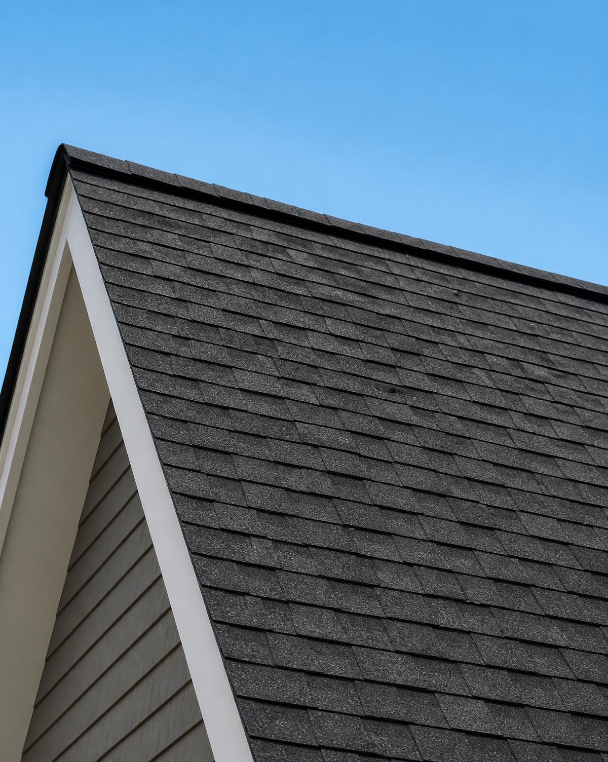 Close view of neatly aligned asphalt shingle courses along a roof ridge